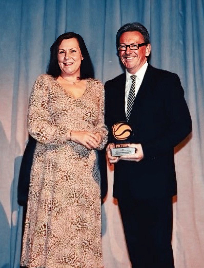 Wayne Holdsworth receiving a Basketball Victoria award on stage
